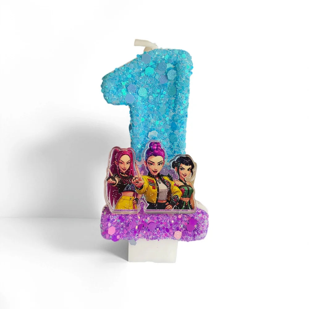 A custom birthday candle shaped like the number one, decorated with blue glitter and featuring three character figures.