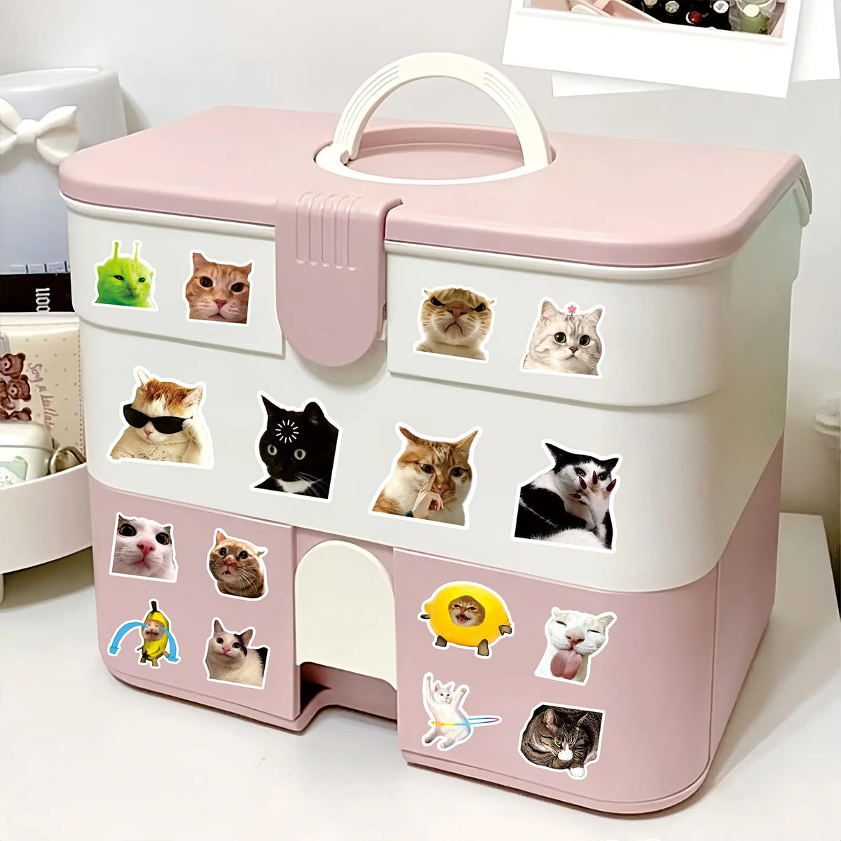 A pink and white storage box featuring various funny cat meme cartoon decals.