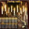 A collection of white floating candles and a magic wand are displayed against an architectural background.