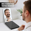 A close-up of a man using a multifunction trifold mirror on a white desk.