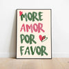 A framed canvas print featuring the text MORE AMOR POR FAVOR in green and pink script on a cream background.