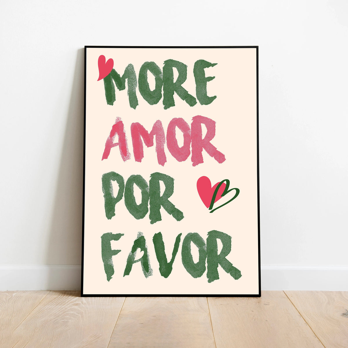 A framed canvas print featuring the text MORE AMOR POR FAVOR in green and pink script on a cream background.