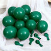 A cluster of dark green latex balloons resting on white sheer fabric.