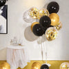 A cluster of gold and black confetti balloons displayed against a white wall with a draped table.