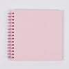 A blank pink spiral-bound kraft paper scrapbook for DIY memory keeping.