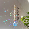 A long string of clear and colored crystals hangs vertically against a light background.