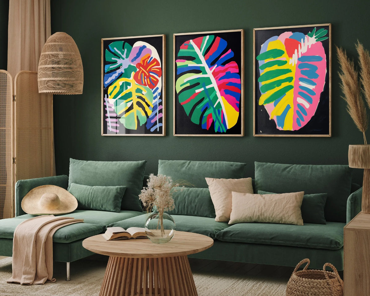 Three canvas prints featuring retro wildflower landscapes displayed on a dark green wall above a sofa.