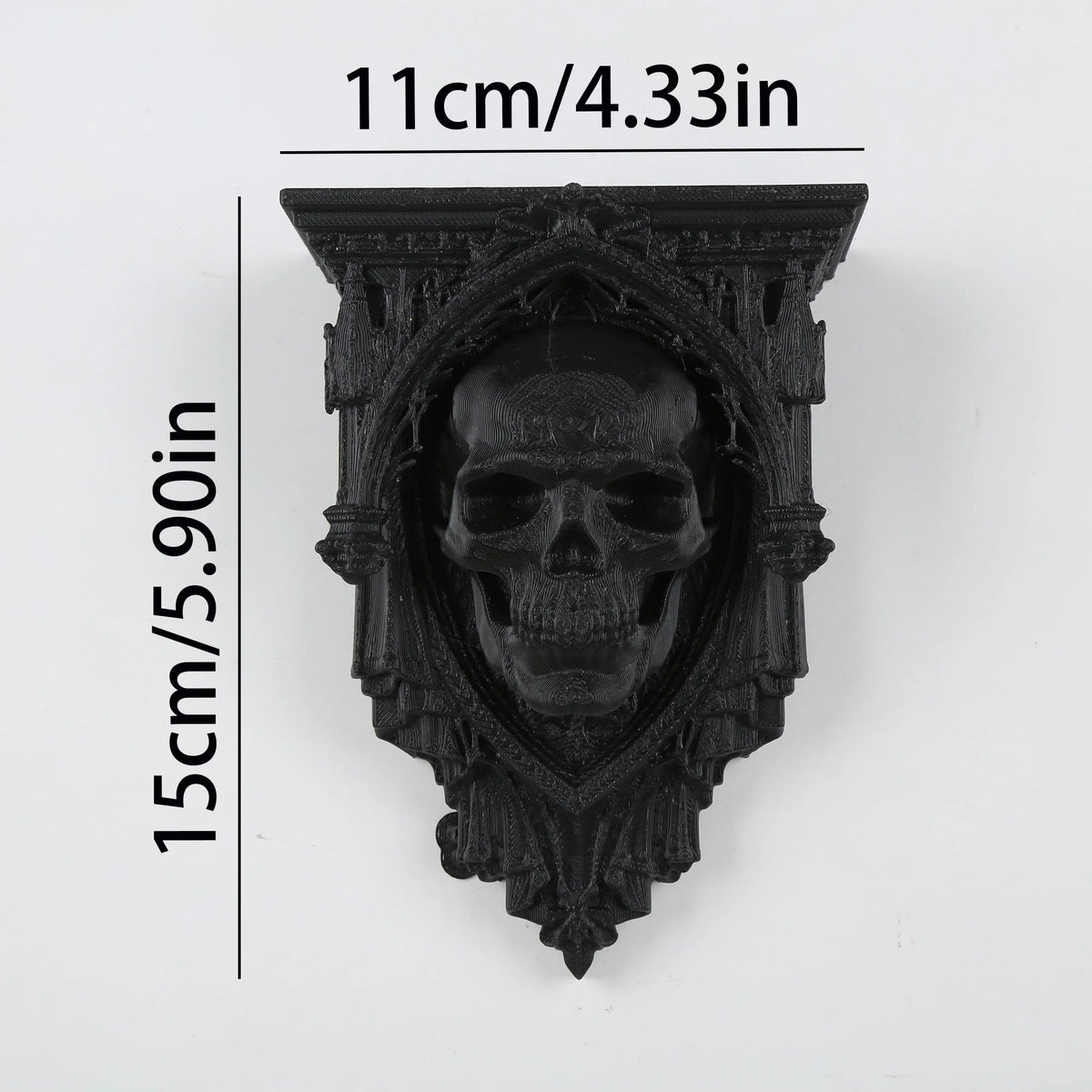 A black ornate Gothic wall shelf featuring a carved human skull design.