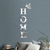 Silver acrylic wall stickers spelling out HOME with a butterfly design on a gray wall.
