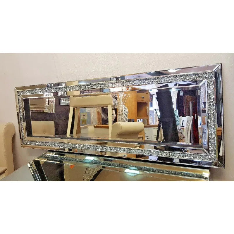 A rectangular silver crystal beveled wall mirror reflecting an interior room.