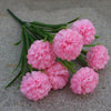 Un bouquet de fleurs artificielles d'hydrangea roses avec des tiges vertes sur une surface grise.
