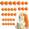 A set of round orange foam cake toppers displayed on white sticks.