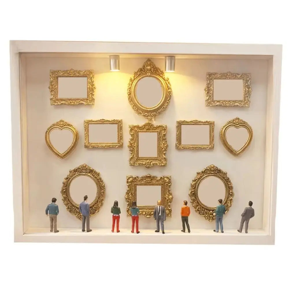 Präsentationsbox mit goldgerahmten Fotosilhouetten und Spiegeln auf hellem Hintergrund