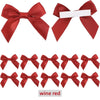 A collection of red satin ribbon bows with white tape, used for gift wrapping and craft projects.