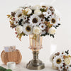 Un bouquet de fleurs artificielles blanches et crème, incluant des tournesols et des pivoines, dans un vase en verre.