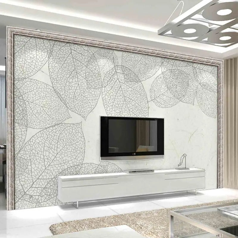 A modern interior featuring a large wall panel with a leaf pattern and a mounted television above a white console.