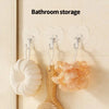 A set of transparent self-adhesive hooks is displayed on a wall, holding white and orange textured items.