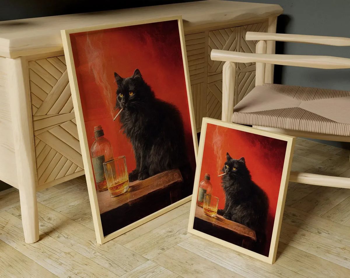 A framed poster depicting a black cat smoking on a wooden surface, displayed next to a light wood cabinet.