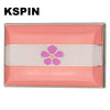 A lapel pin featuring horizontal stripes of pink and white with a purple flower design.