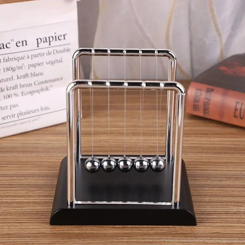 A silver Newton's cradle with glass balls on a black base.