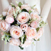 A lush bridal bouquet of pink and blush roses with a champagne finish, arranged in a natural style.