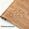 A wooden cutting board with water droplets on its surface, showing a realistic wood grain texture.