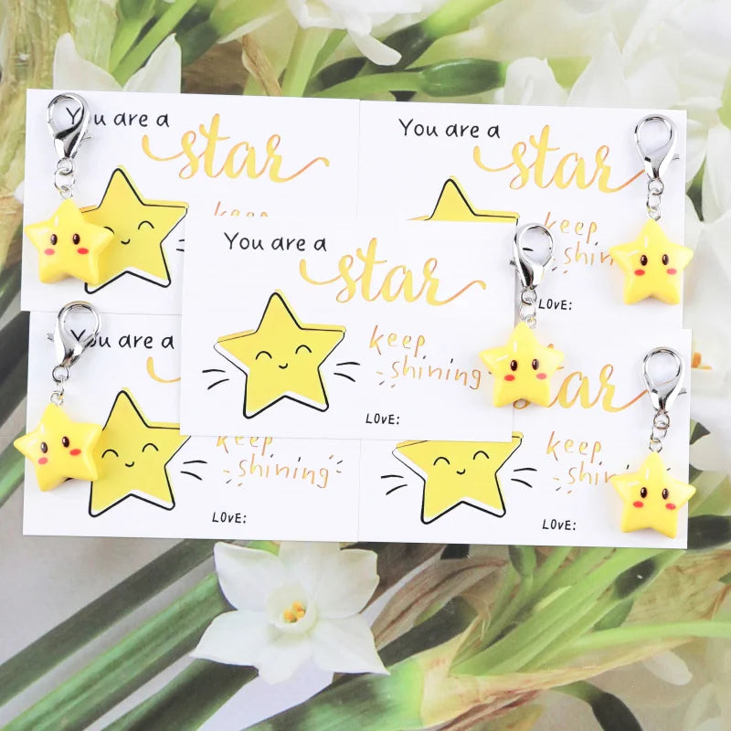A set of inspirational star keychains featuring yellow and gold stars on white cards.