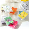 A collection of scented wax melts in various colors and scents, including vanilla, jasmine, bergamot, and lemon.