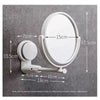 A white, round vanity mirror with a rotating feature is mounted on a gray wall.