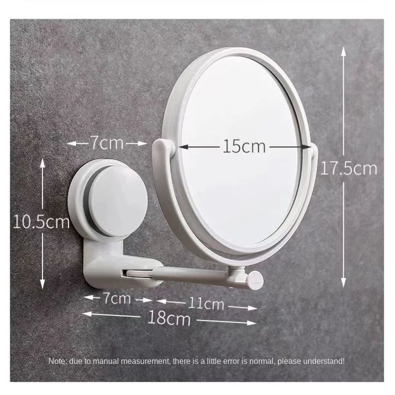 A white, round vanity mirror with a rotating feature is mounted on a gray wall.
