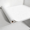 Roll of white matte peel and stick decor stickers placed inside a white container.