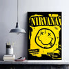 A black poster featuring the Nirvana logo and smiley face in yellow grunge style, displayed on a shelf.