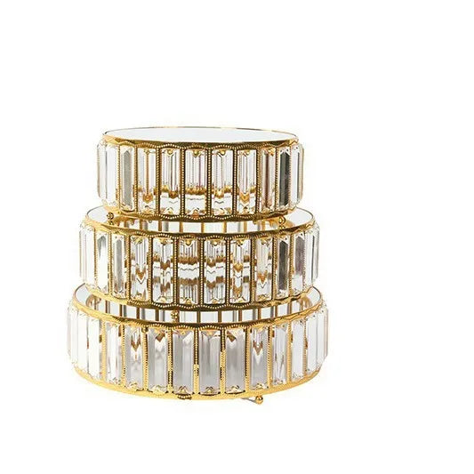 A set of three clear crystal and gold-toned metal cake stands stacked together.