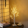 Dekorative LED-Weihnachtsbaumlichter vor gelter Wand neben Fenstergardin und Büchern.