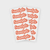 A sheet of orange-red stickers featuring the word sample multiple repeated in a playful font.