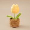 Handcrafted crochet yellow tulip plant growing in a brown crocheted pot
