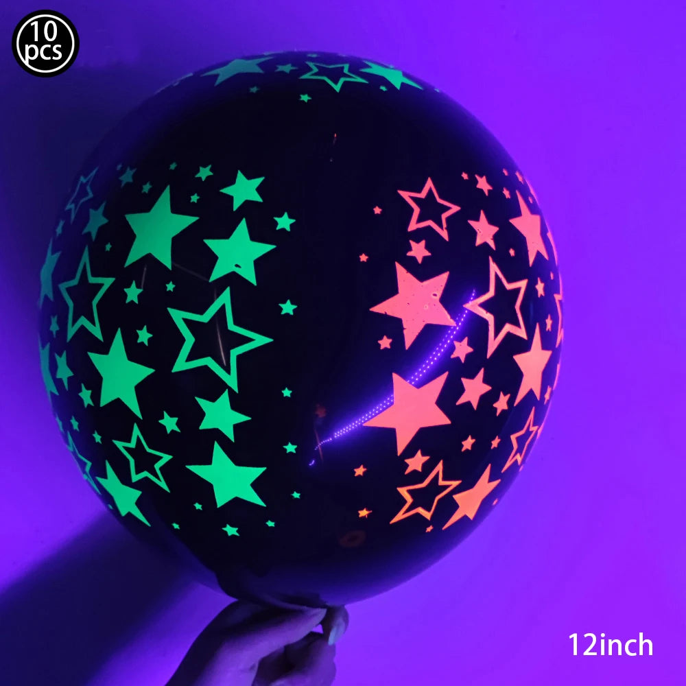 A dark latex balloon filled with neon glow-in-the-dark stars, held by a hand.