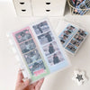 A hand holds a vertical transparent photo card organizer filled with multiple photocards.