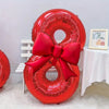 A large red foil number balloon shaped like the number 8, tied with a matching red bow.