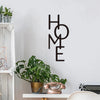 Black metal word art wall decor spelling out HOME on a white wall