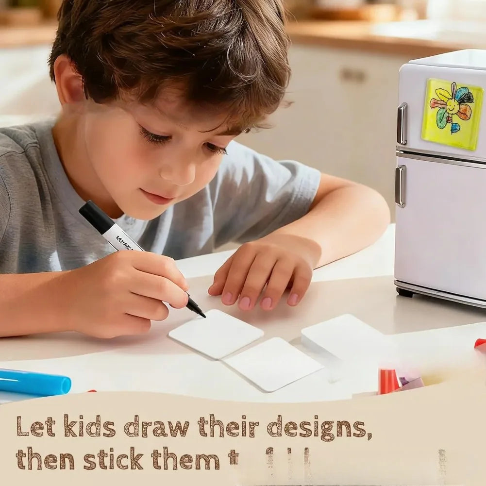A young boy is drawing designs on paper with a pen, preparing to make DIY acrylic fridge magnets.
