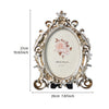 Vintage gold oval resin picture frame with ornate detailing and a soft pink rose design