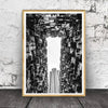Black and white photograph of a city skyline viewed through an architectural corridor
