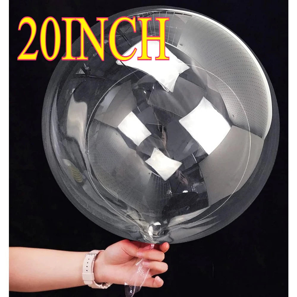 A large clear bubble balloon is being held by a hand against a dark background.
