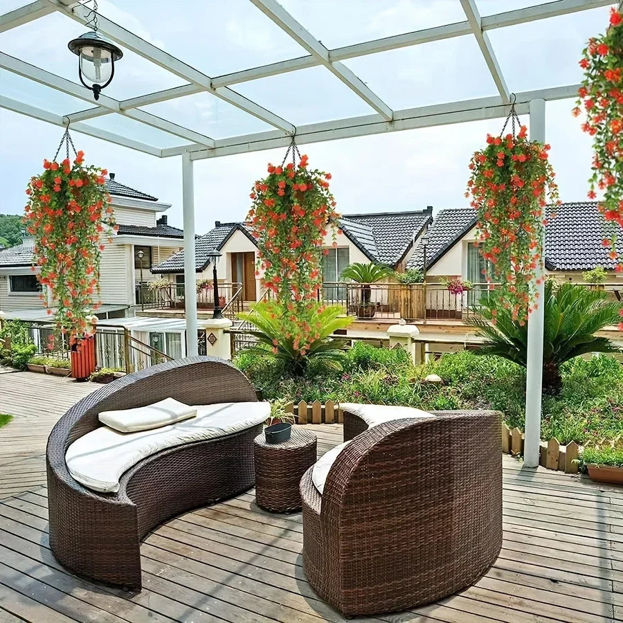 Three faux eucalyptus hanging plants displayed on a wooden deck under a pergola.
