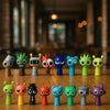 A collection of handcrafted musical figurines in various colors and shapes displayed on a wooden surface.