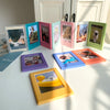 A collection of colorful magnetic photo frames displaying various photographs and scenes.