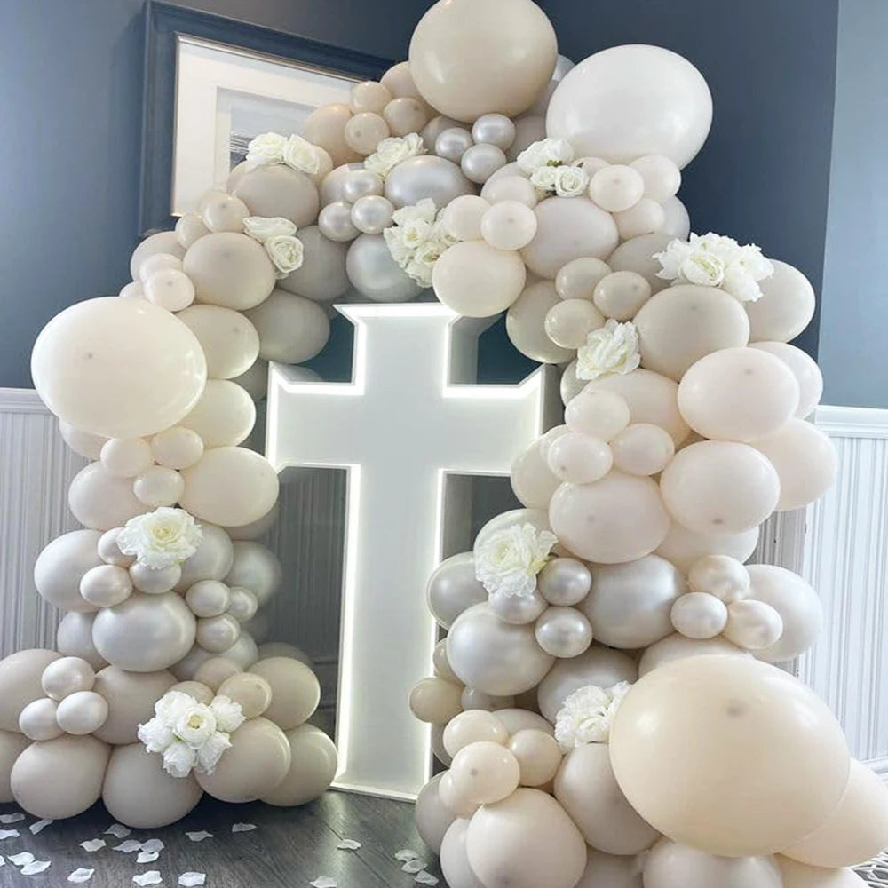 A large archway made of white and gray latex balloons for a party decoration.