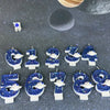 A set of twelve blue planet design birthday candles for ages 1 through 9 arranged on a dark gray surface.