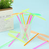 A collection of colorful bamboo dragonfly flying propeller toys scattered on a light blue surface.
